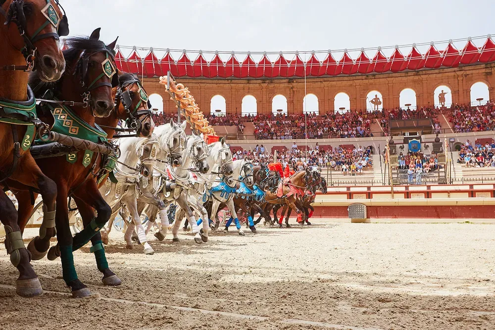 Course effrénée de quadriges et chevaux dans les arènes du Signe du Triomphe au Puy du Fou pour vos vacances en Vendée au camping Le California.